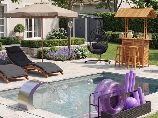 Een modern terras met een gevoerde fauteuil onder een beige parasol, een hangstoel en een houten tuinbar met krukken, omringd door een verzorgde tuin, paarse bloemen en een kleine schuur op de achtergrond.