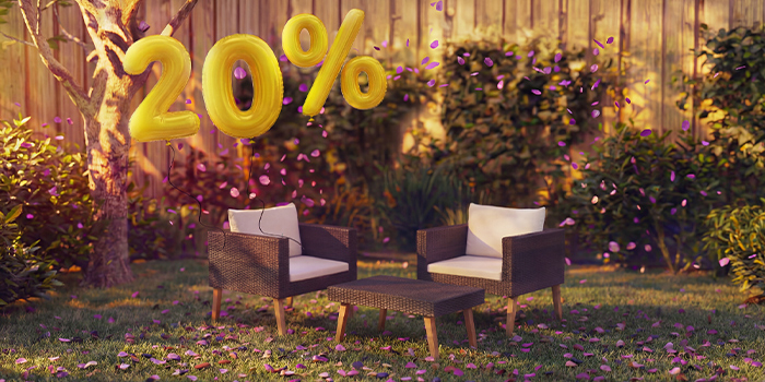 Rattan lounge stoelen voor buiten met kussens en een kleine tafel in een tuinsetting, versierd met roze confetti en gouden ballonnen met “20% korting”, die seizoensdeals op tuin-loungebanken benadrukken.